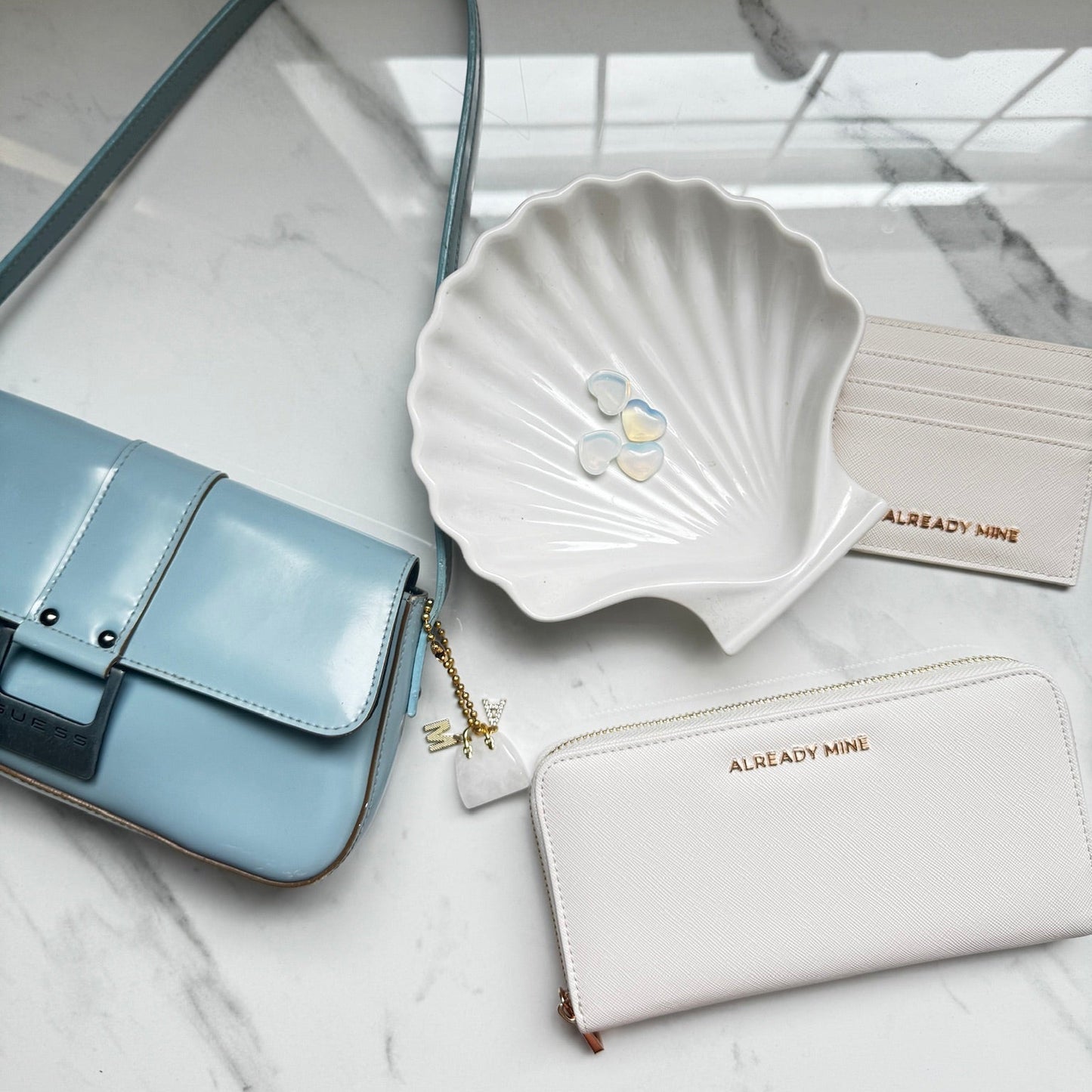 Ecru manifestation wallet styled with candle and crystal representing calm, clarity, and ease with money