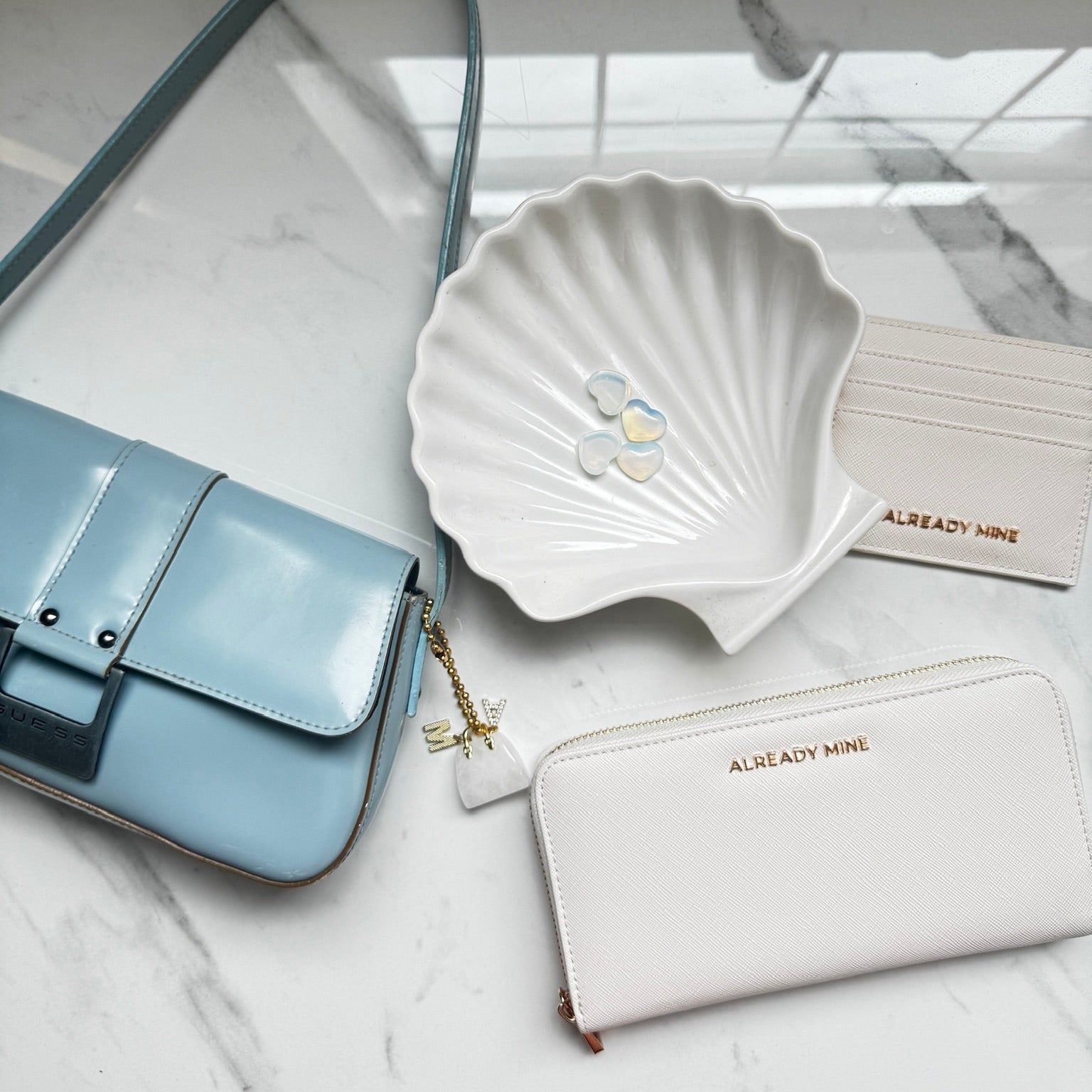 Ecru manifestation wallet styled with candle and crystal representing calm, clarity, and ease with money