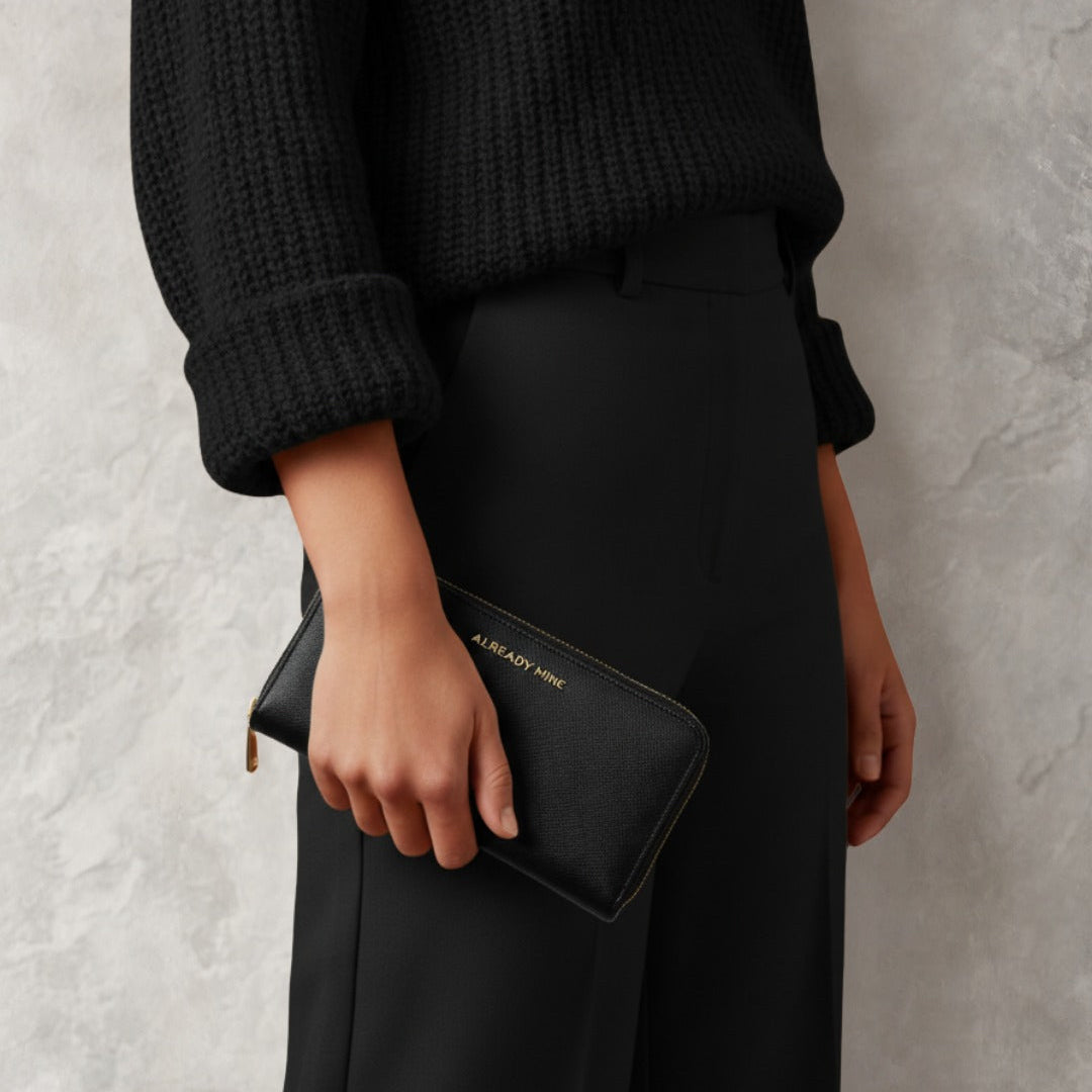 Woman holding Black vegan leather manifestation wallet by Already Mine designed for protection and powerful money energy

